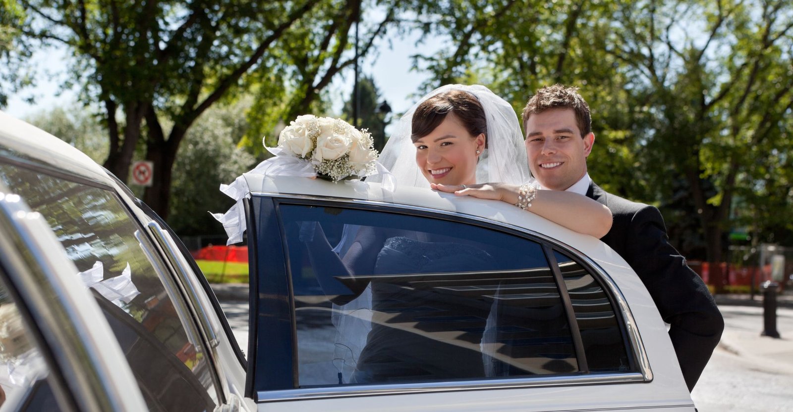 wedding couple getting in the back of a limo